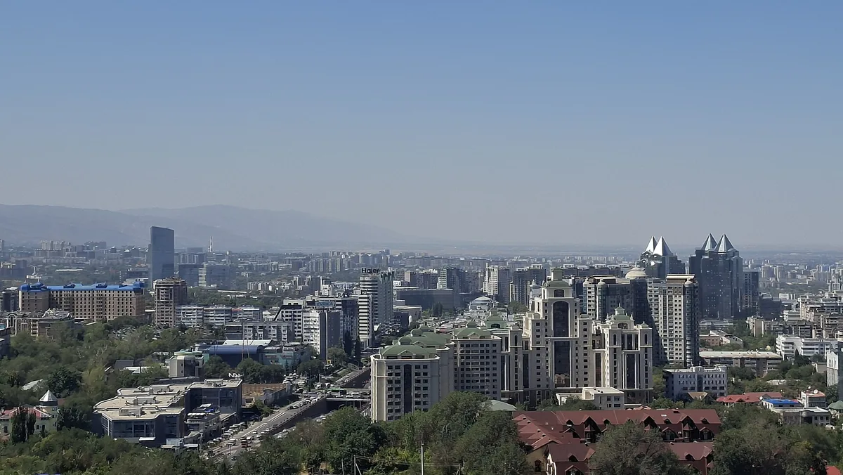 The Almaty skyline seen from Kok-Tobe hill, the Tien Shan range hazy behind it.