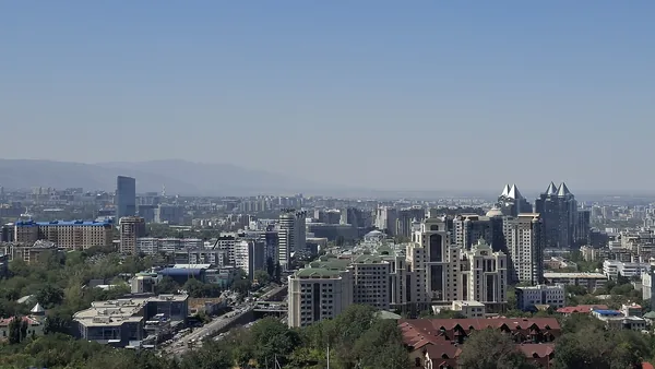 The Almaty skyline seen from Kok-Tobe hill, the Tien Shan range hazy behind it.