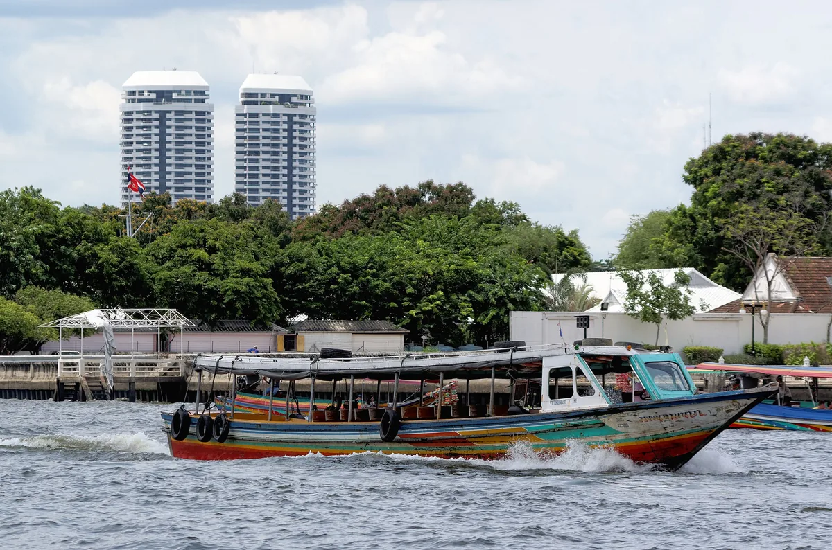 A longtail boat running down the Chao Phraya river through Bangkok.