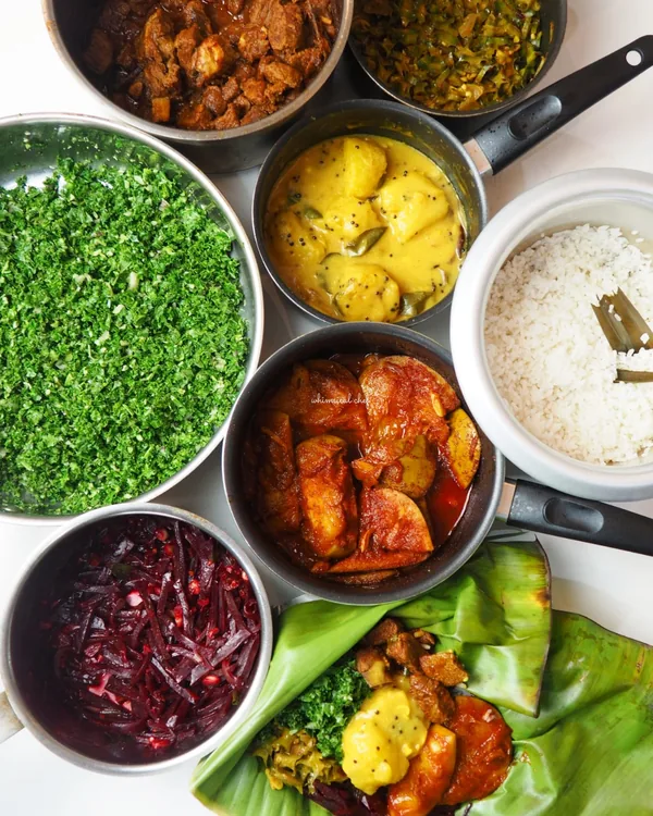 A Sri Lankan rice and curry spread, rice ringed by small dishes.