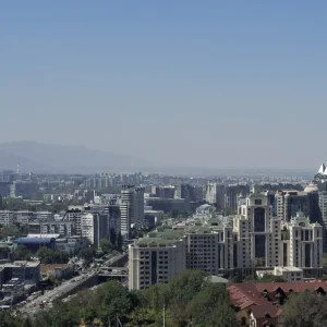 The Almaty skyline seen from Kok-Tobe hill, the Tien Shan range hazy behind it.