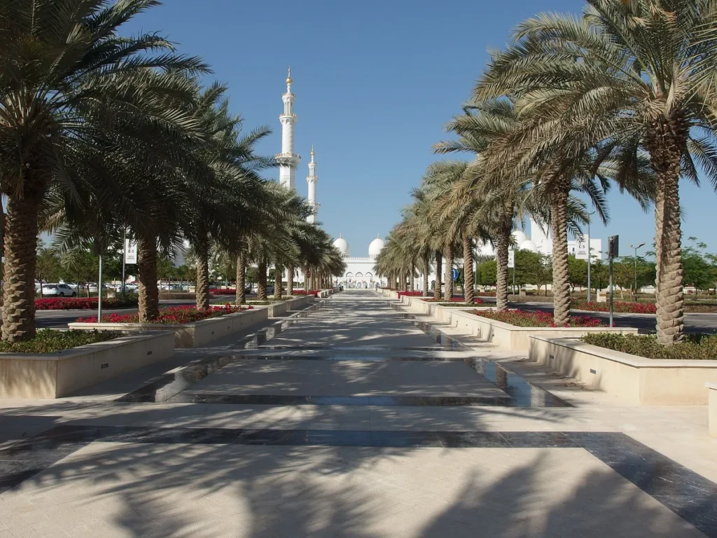 The palm avenue leading to the white domes and minarets of the Sheikh Zayed Grand Mosque, Abu Dhabi.